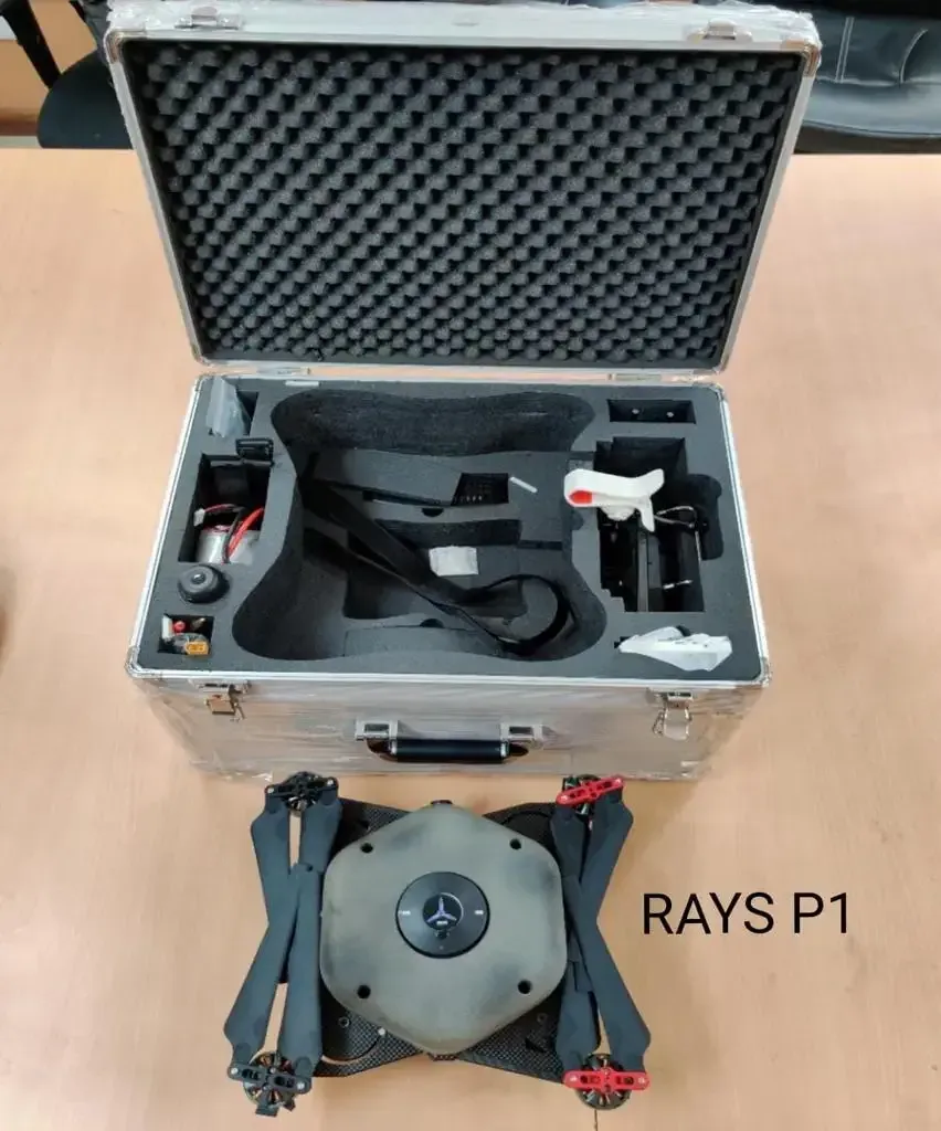 A RAYS P1 drone with folded arms next to its open aluminium carry case fitted with foam padding