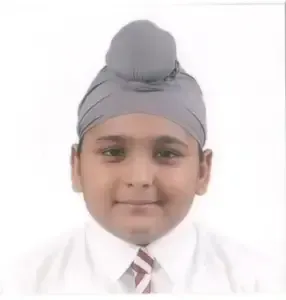 Portrait photo of a young Sikh boy wearing a school uniform and grey turban